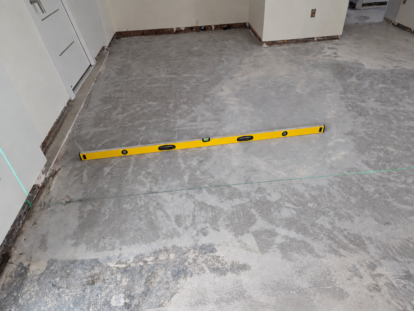 Prepared concrete subfloor checked with a long level and laser lines